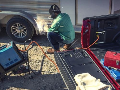 2023 Ford F-150 view of man using pro power onboard feature at a work site